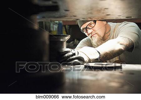Stock Photograph - Caucasian worker working in factory. Fotosearch