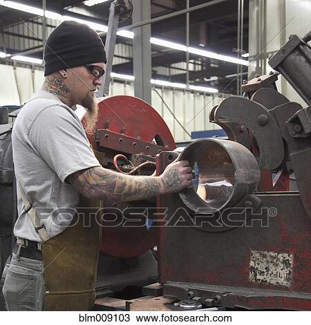 Caucasian worker working in metal pipe in factory View Large Photo Image Stock Image - Caucasian worker working in metal pipe in factory. Fotosearch