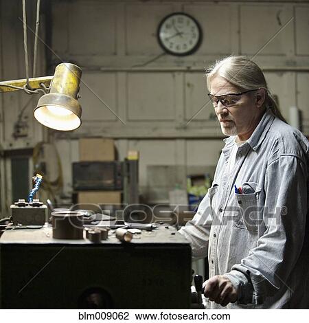 Stock Image - Caucasian worker working on factory. Fotosearch