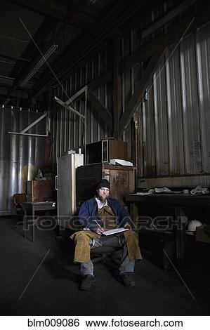 Caucasian worker writing on clipboard in factory View Large Photo Image Stock Photograph - Caucasian worker writing on clipboard in factory. Fotosearch