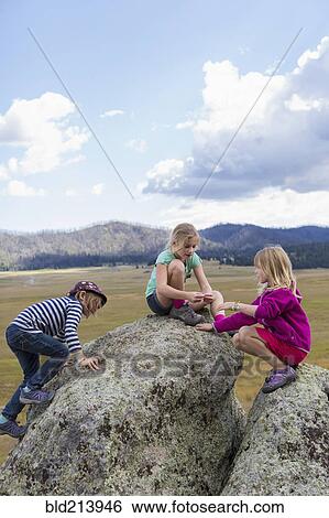 Children exploring rock formations in remote landscape View Large Photo Image Stock Photograph - Children exploring rock formations in remote landscape. Fotosearch