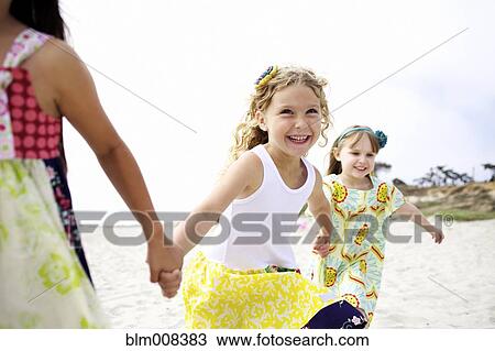 Children holding hands running on beach View Large Photo Image Stock Image - Children holding hands running on beach. Fotosearch