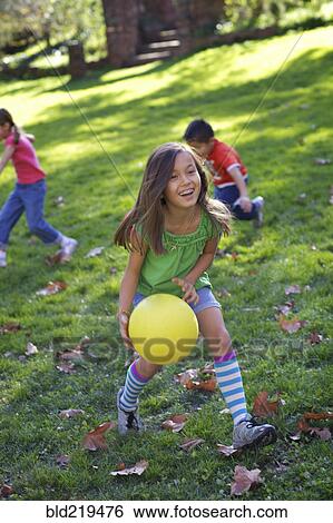 Stock Photograph - Children playing with ball in park. Fotosearch