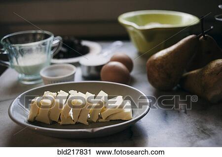 Stock Image - Close up of baking ingredients and pears on marble counter. Fotosearch