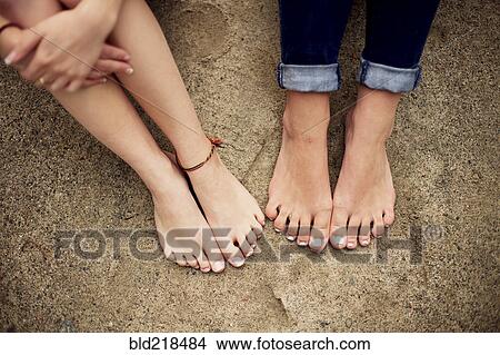 Picture - Close up of barefoot girls on rock. Fotosearch