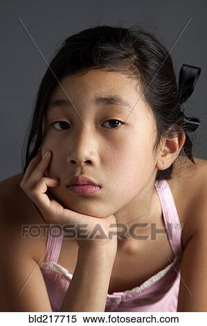 Close up of bored Asian girl View Large Photo Image Stock Photography - Close up of bored Asian girl. Fotosearch