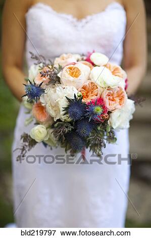 Stock Photo - Close up of bride holding bouquet of flowers. Fotosearch