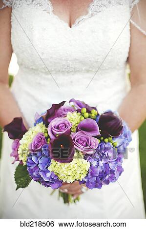 Stock Photograph - Close up of bride holding wedding bouquet. Fotosearch