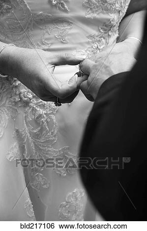Close up of bride putting wedding ring on finger of groom View Large Photo Image Stock Photograph - Close up of bride putting wedding ring on finger of groom. Fotosearch