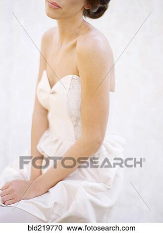 Stock Image - Close up of bride wearing wedding dress. Fotosearch
