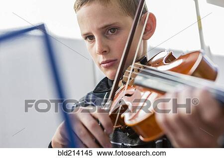 Stock Photography - Close up of Caucasian boy playing violin. Fotosearch