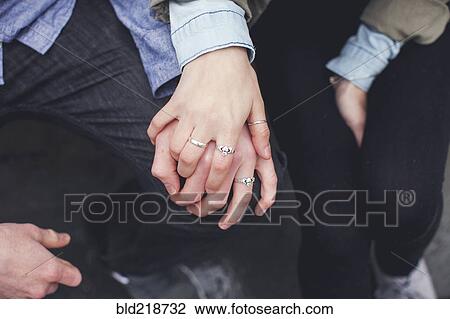 Stock Image - Close up of Caucasian couple holding hands. Fotosearch