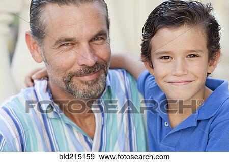 Close up of Caucasian father and son hugging View Large Photo Image Stock Photo - Close up of Caucasian father and son hugging. Fotosearch