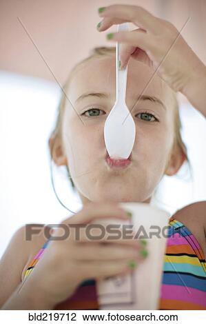 Close up of Caucasian girl eating ice cream View Large Photo Image Stock Image - Close up of Caucasian girl eating ice cream. Fotosearch