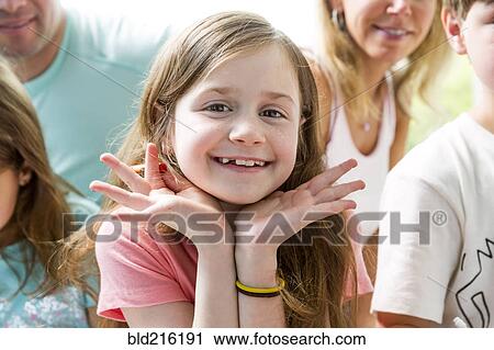 Stock Image - Close up of Caucasian girl smiling with family. Fotosearch