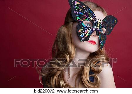 Stock Image - Close up of Caucasian girl wearing butterfly mask. Fotosearch