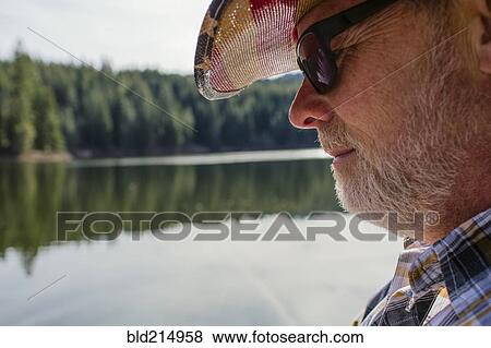 Stock Photo - Close up of Caucasian man standing near lake. Fotosearch