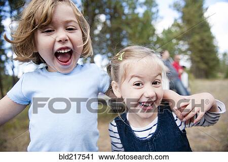 Stock Image - Close up of Caucasian sisters hugging outdoors. Fotosearch