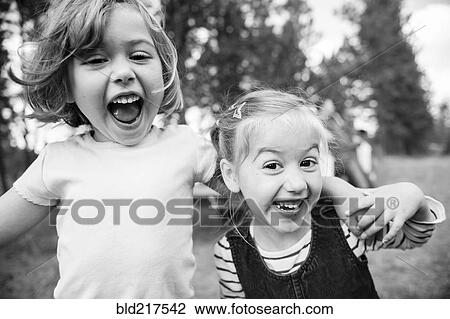 Stock Image - Close up of Caucasian sisters hugging outdoors. Fotosearch