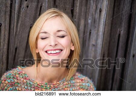 Stock Image - Close up of Caucasian woman laughing with eyes closed. Fotosearch