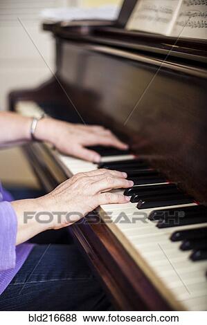 Stock Photo - Close up of Caucasian woman musician playing piano. Fotosearch