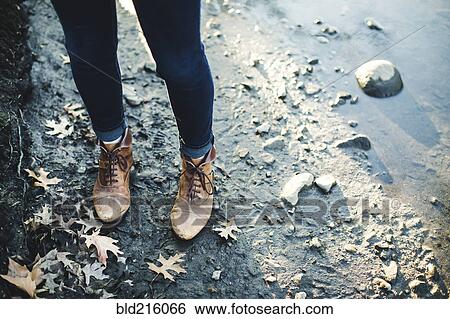 Stock Photograph - Close up of Caucasian woman standing near puddle. Fotosearch