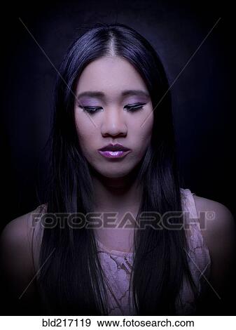 Stock Photo - Close up of Chinese woman with long hair looking down. Fotosearch