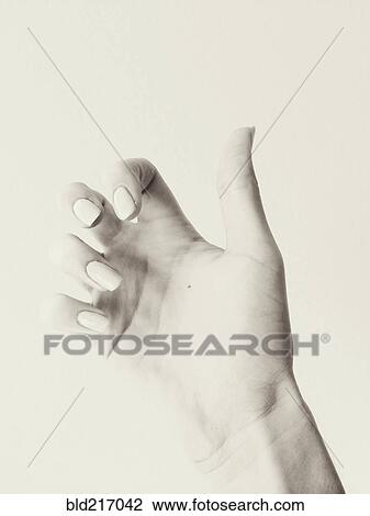 Stock Image - Close up of curled fingers on hand of woman. Fotosearch