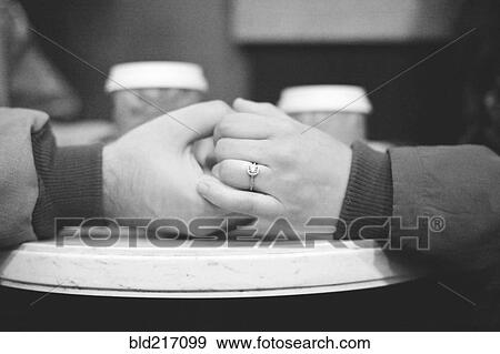 Stock Photo - Close up of engaged couple holding hands. Fotosearch