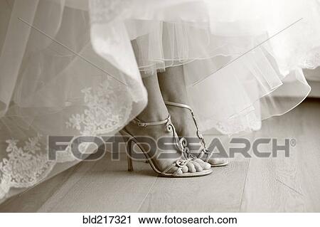 Stock Image - Close up of feet of bride in wedding shoes. Fotosearch