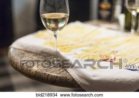 Picture - Close up of fresh pasta and glass of white wine. Fotosearch