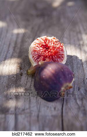 Stock Image - Close up of fresh sliced fig on board. Fotosearch