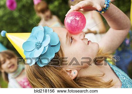 Close up of girl balancing ball on her nose View Large Photo Image Stock Photograph - Close up of girl balancing ball on her nose. Fotosearch