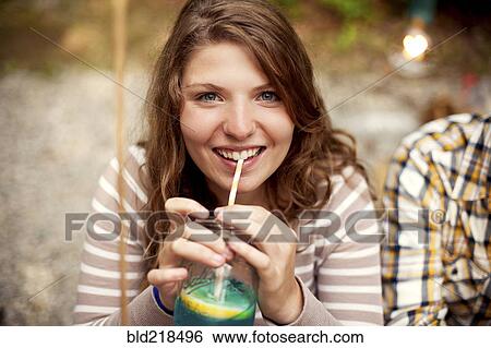Stock Photograph - Close up of girl drinking beverage with straw. Fotosearch