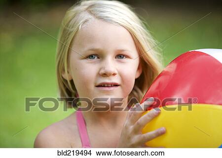 Picture - Close up of girl holding beach ball. Fotosearch