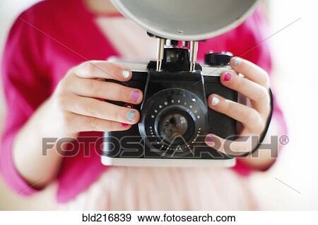 Stock Photo - Close up of girl holding camera. Fotosearch