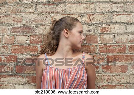 Close up of girl leaning on brick wall View Large Photo Image Stock Photograph - Close up of girl leaning on brick wall. Fotosearch