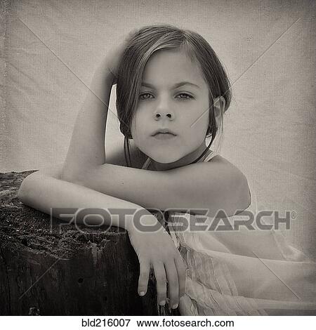 Stock Photo - Close up of girl leaning on tree stump. Fotosearch