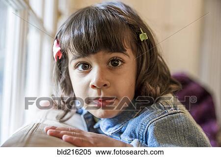 Stock Photography - Close up of girl sitting on sofa. Fotosearch