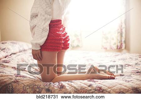 Close up of girl wearing frilly shorts kneeling on bed View Large Photo Image Stock Image - Close up of girl wearing frilly shorts kneeling on bed. Fotosearch