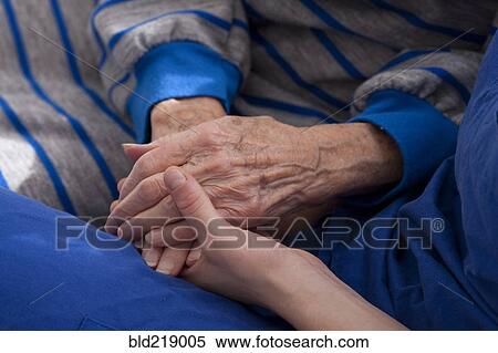Stock Photography - Close up of granddaughter holding hands of grandmother. Fotosearch