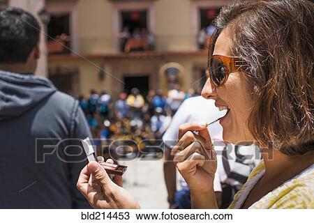 Close up of Hispanic woman applying makeup in mirror outdoors View Large Photo Image Stock Image - Close up of Hispanic woman applying makeup in mirror outdoors. Fotosearch