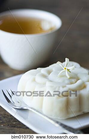 Stock Image - Close up of jasmine tea and rice cake. Fotosearch