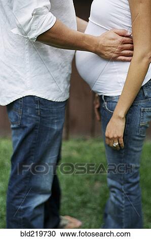 Close up of man hugging pregnant wife in backyard View Large Photo Image Stock Image - Close up of man hugging pregnant wife in backyard. Fotosearch