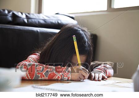 Stock Photo - Close up of mixed race girl doing homework. Fotosearch