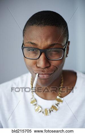 Stock Photography - Close up of mixed race woman smoking cigarette. Fotosearch