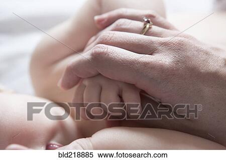 Close up of mother holding hand of baby girl View Large Photo Image Stock Photography - Close up of mother holding hand of baby girl. Fotosearch