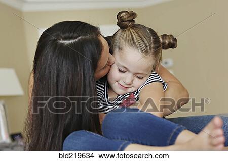 Picture - Close up of mother kissing cheek of daughter. Fotosearch