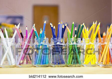 Stock Image - Close up of multicolor pencils organized in jars. Fotosearch