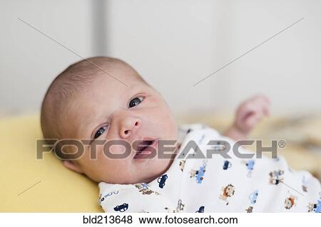 Stock Photo - Close up of newborn mixed race baby looking at camera. Fotosearch